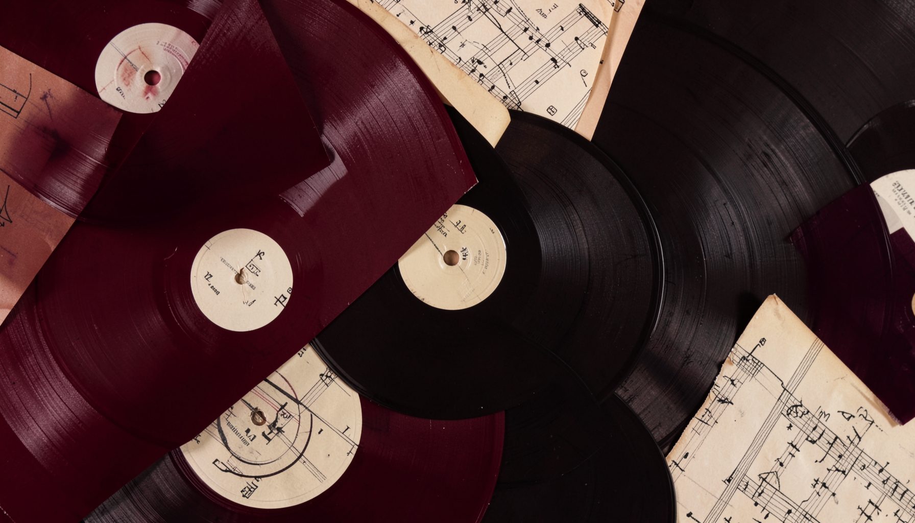 A warm-toned abstract composition of overlapping vinyl records and sheet music in deep burgundy, cream, and charcoal, evoking a rich musical heritage